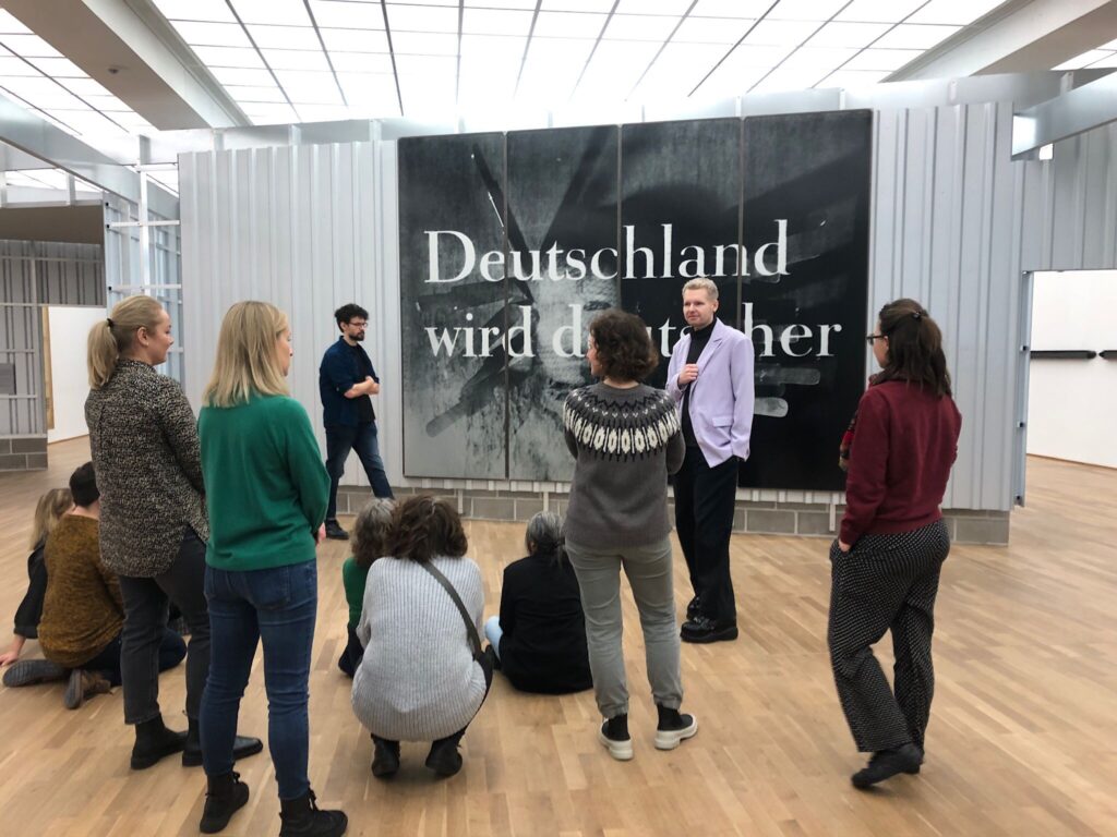 People meeting in a room next to a poster