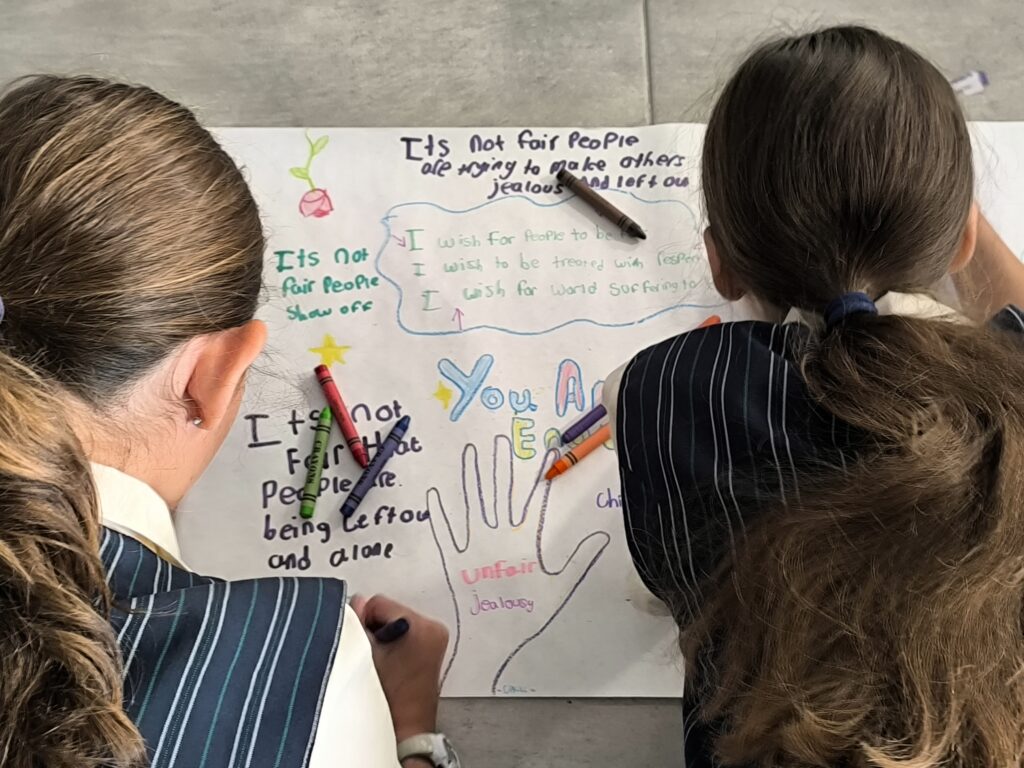 Two children writing and drawing on paper