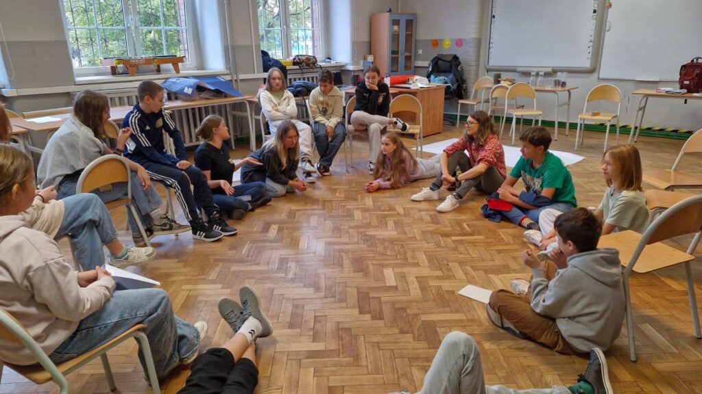 Children in classroom sitting on the floor