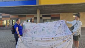 People showing a decorated sheet