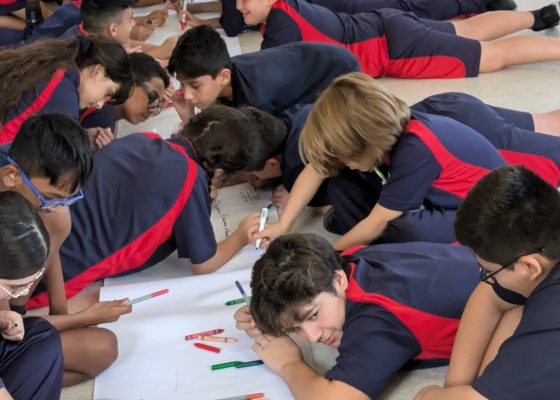 Children working on drawings on the floor